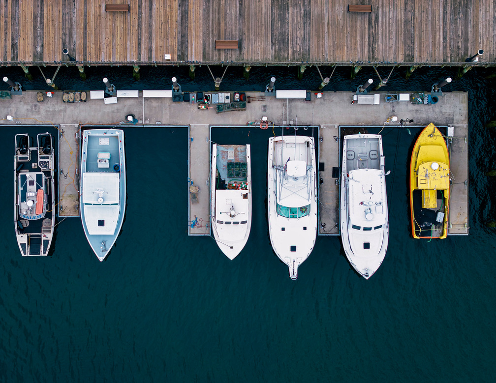 Aerial overhead photograph of six boats docked side by side at a pier in Beverly Harbor Massachusetts